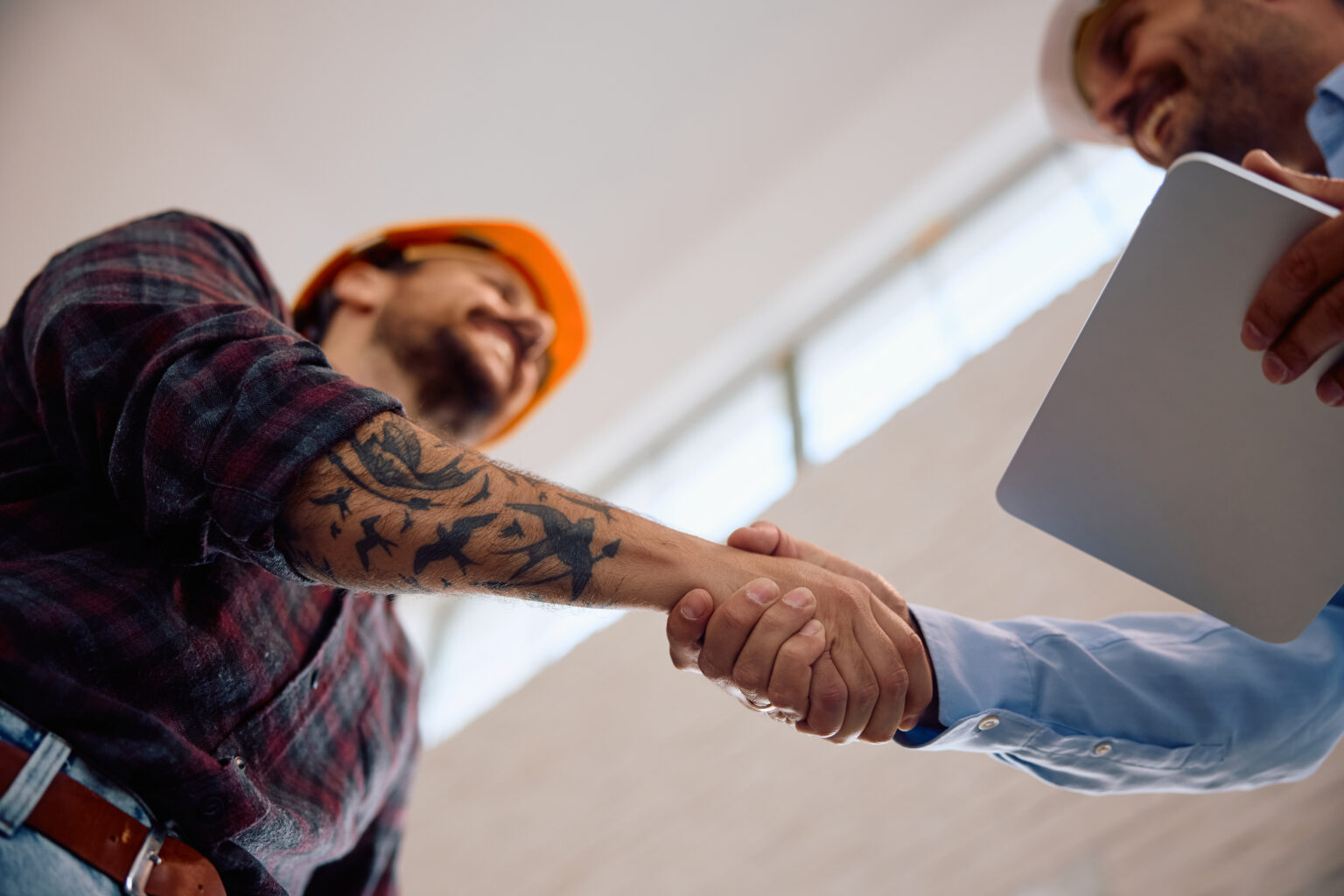 Poignée de main entre un professionnel du bâtiment et un client, symbolisant le partenariat avec EDS TP à Sérézin-du-Rhône.